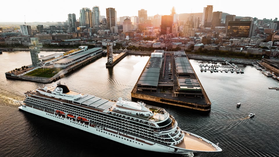 A large cruise ship named Viking Star docked at a waterfront with a city skyline in the background, captured during sunrise or sunset.