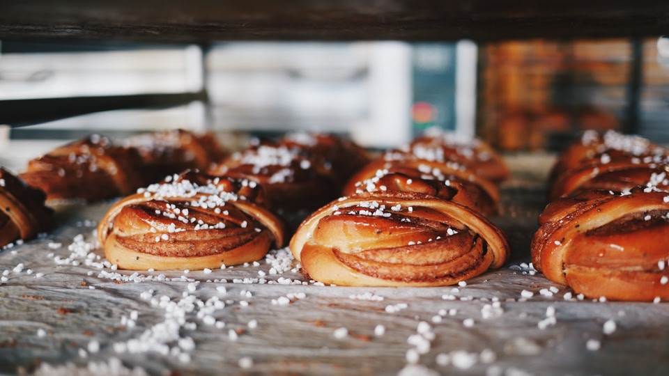 A close-up of freshly baked cinnamon buns sprinkled with powdered sugar.