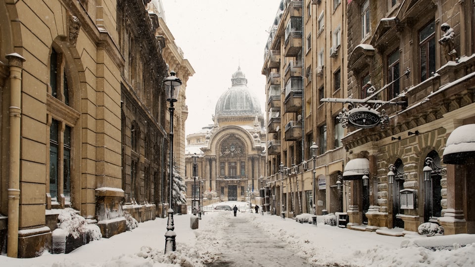 Snow-covered street in Bucharest with historic buildings