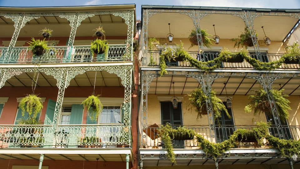 Two historic buildings with ornate wrought iron balconies in New Orleans, Louisiana.
