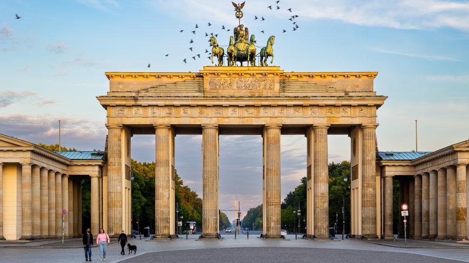 Brandenburg Gate in Berlin with a chariot statue on top and people walking by