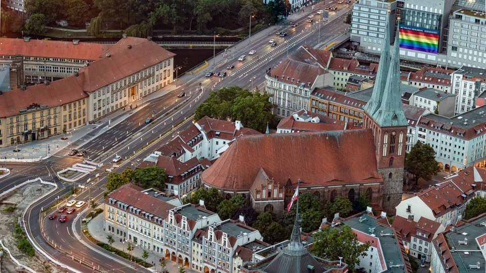 Aerial view of St. Nicholas Church in Mitte, Berlin, surrounded by buildings and roads.