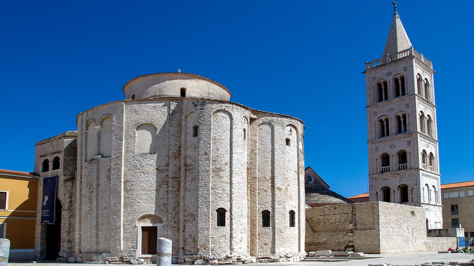 Ancient stone church with a tall bell tower in Zadar, Croatia.