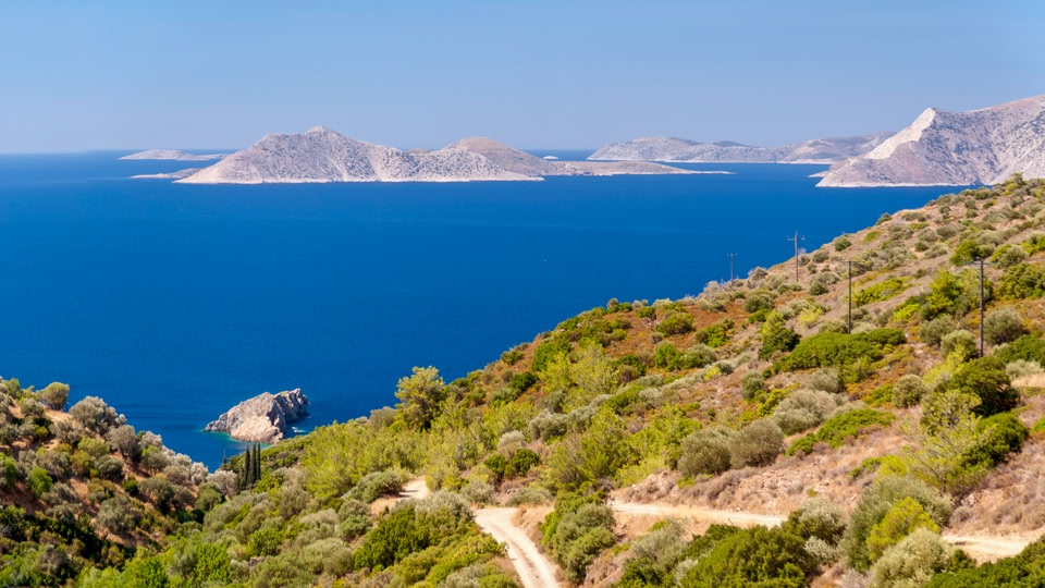 A scenic view of rugged hills and a deep blue sea in Samos, North Aegean, Greece.