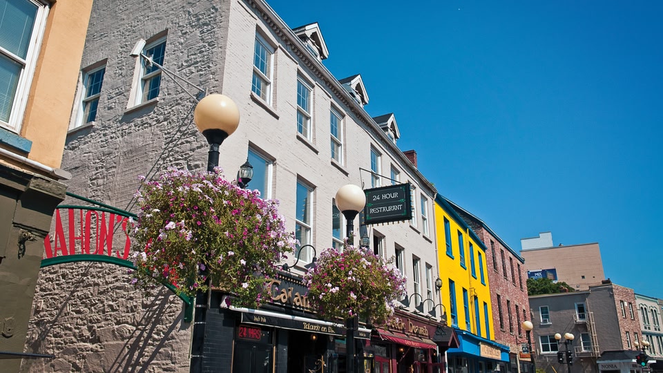 Colorful buildings with signs indicating bars and cafes on a city street in Saint John, New Brunswick, Canada.