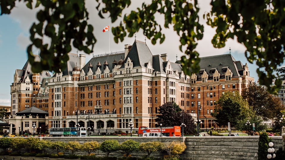 The Fairmont Empress Hotel in Victoria, British Columbia, Canada, with a Canadian flag waving on top.
