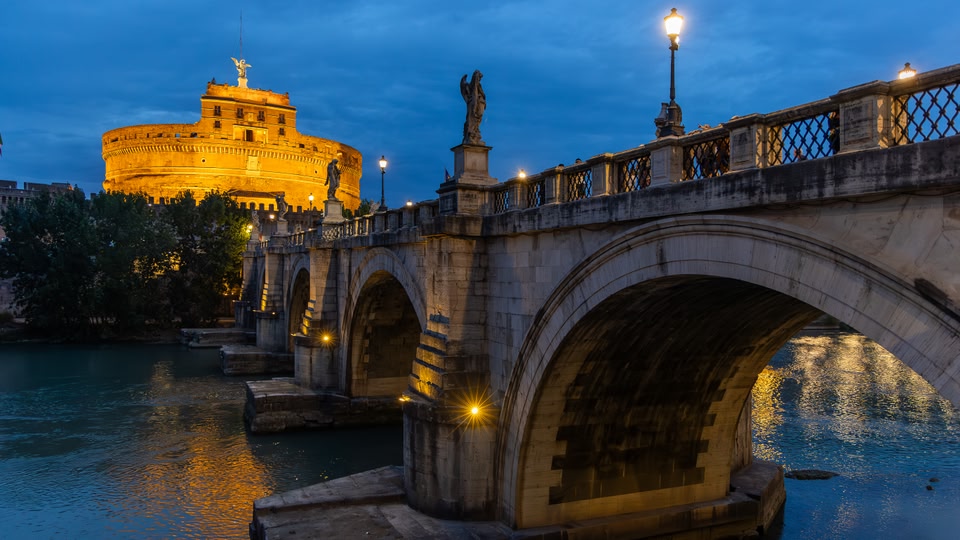 Illuminated bridge and Castel Sant'Angelo at night in Rome, Italy