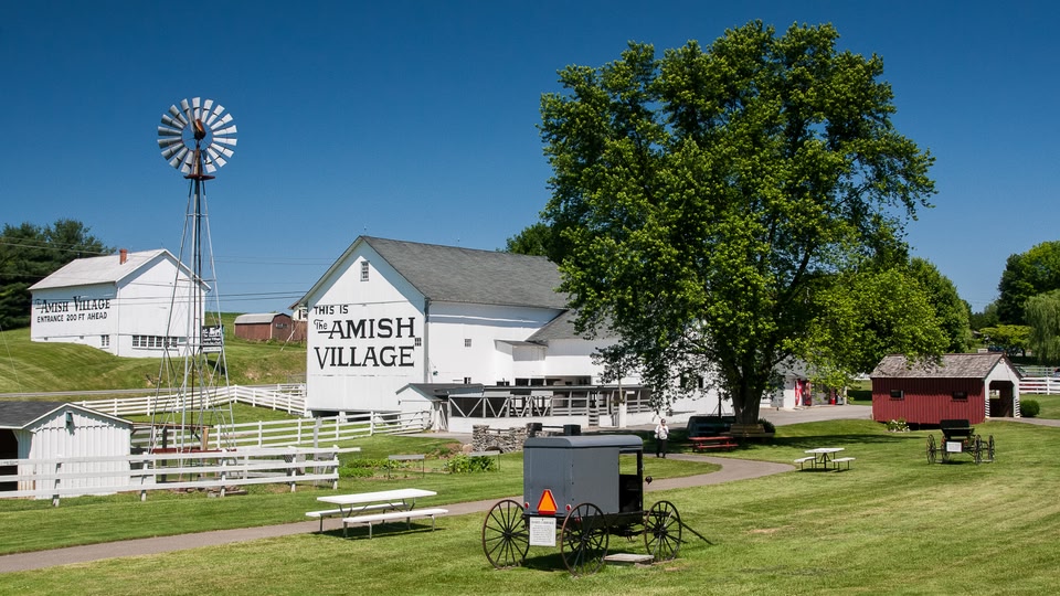 A view of the Amish Village in Lancaster, Pennsylvania, showing traditional Amish buildings and a buggy.