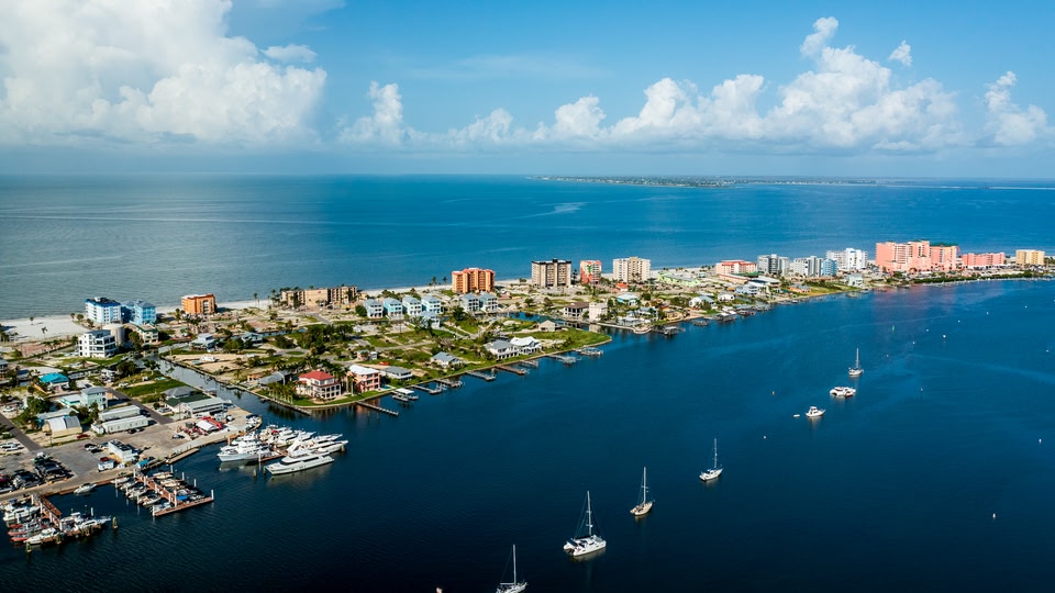 Aerial view of a coastal town with numerous buildings and boats in the water.
