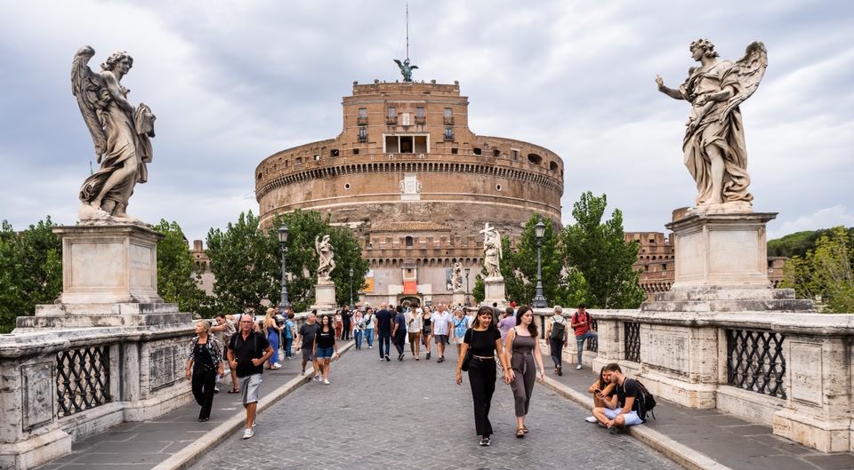 Crowded bridge with statues leading to Castel Sant'Angelo in Rome
