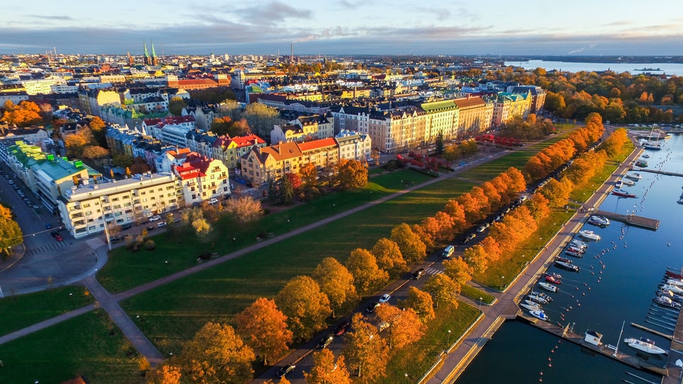 Aerial view of a city skyline with colorful autumn trees and a waterfront