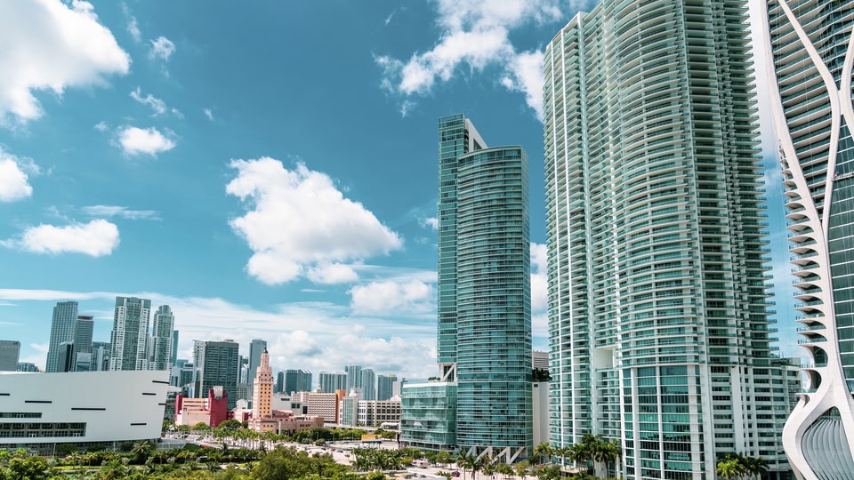 A panoramic view of Miami's skyline with modern skyscrapers and a clear blue sky.